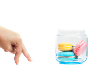 Hand moving towards a jar of macaroons