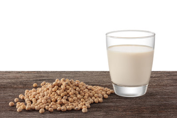 Glass of soy milk and soy bean on wooden background.