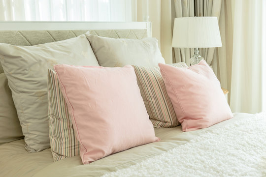 cozy bedroom interior with pink pillows and reading lamp on beds