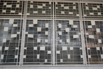 Vintage metal window blinds of an old shop house exterior.  