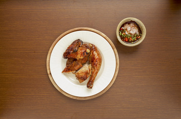 Grilled chicken with spicy sauce on wood background 