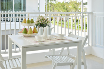 beautiful terrace with white furniture and tea or coffee set at