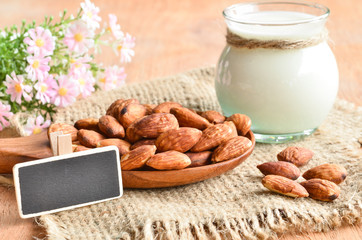 Almond milk in glass with almonds