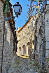 Narrow medieval street in walled city Vila Vella in Catalonia, Spain