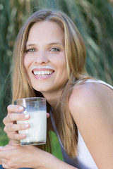Junge hübsche Frau trinkt ein Glas Milch