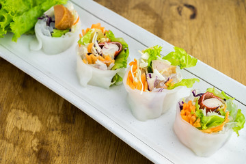 Portion of spring rolls , vegetables and in noodle tube