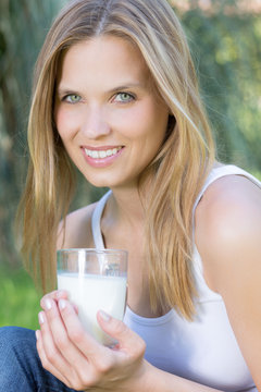 Junge hübsche Frau trinkt ein Glas Milch