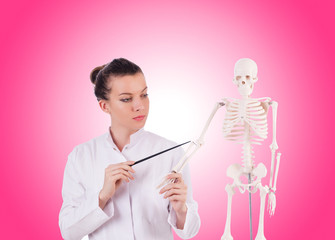 Doctor with skeleton against gradient 