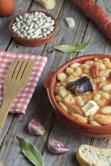 Spanish fabada in an earthenware dish with ingredients