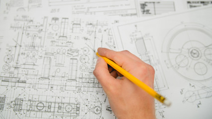 The hand keep pencil and work with blueprints engineering project