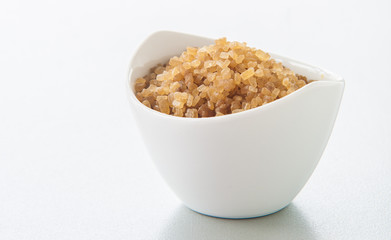 sugar in a white bowl on white background