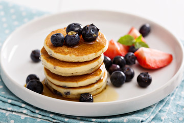 Stack of small pancakes with berries