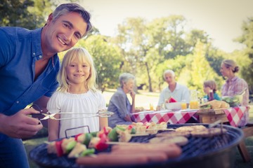 Happy father doing barbecue with her daughter