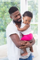 Obraz premium Happy father with baby girl on couch