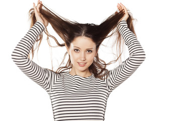 smiling young woman holding her hair with her hands