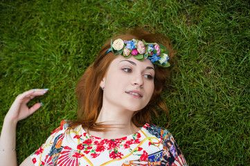 Beautiful young woman in a wreath of flowers smiling portrait on nature, the joy of life, smile