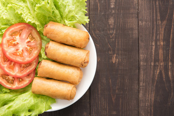 Fried Chinese traditional spring rolls on wooden background.