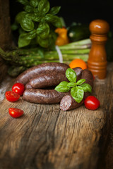 Black pudding, with cut slices, on chopping board over stone background. Krupniok really Polish...