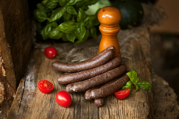 Black pudding, with cut slices, on chopping board over stone background. Krupniok really Polish...