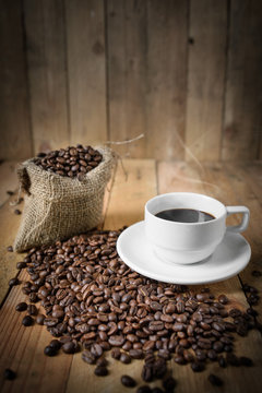 Cup of black coffee and coffee beans