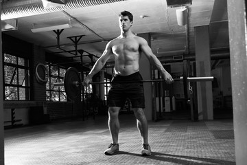 Fototapeta premium Black And White Shot Of Man In Gym Lifting Weights