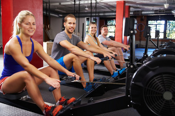 Portrait Of Gym Class Working Out On Rowing Machines