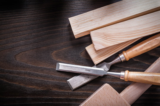 Lump hammer flat chisels and wooden bricks on brown vintage wood