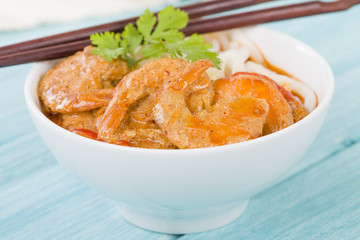 Thai Prawn Curry with Noodles - Thai red curry with prawns served with rice noodles in a white bowl.