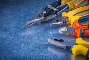 Tin snips pliers wire-cutter on scratched vintage metallic backg