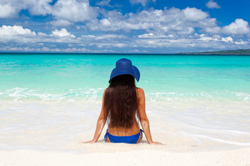Fototapeta na wymiar Woman on beach in summer hat