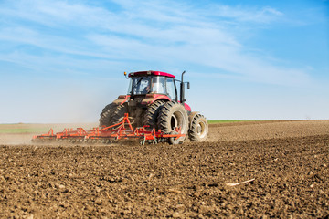 Farmer in tractor preparing land with seedbed cultivator