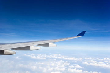 Fototapeta na wymiar Wing of airplane in blue sky