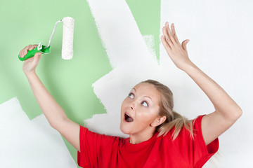 Happy woman in red t-shirt with paint roller in hand