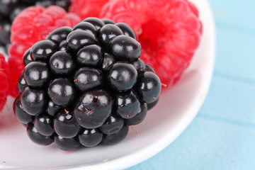 Blackberry and raspberries on white plate