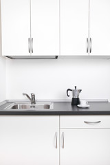 Percolator and cup of coffee on worktop