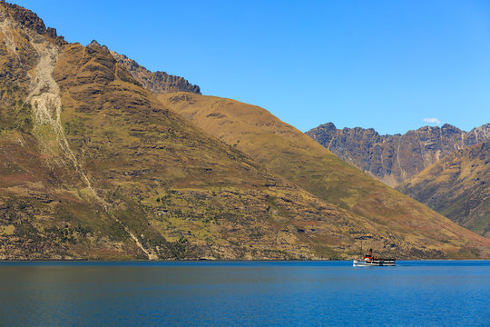 Steamship sailing in front of the mountains in Queenstown, New Z