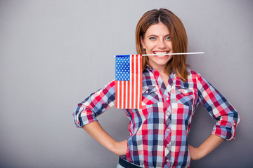 Woman holding USA flag in teeth