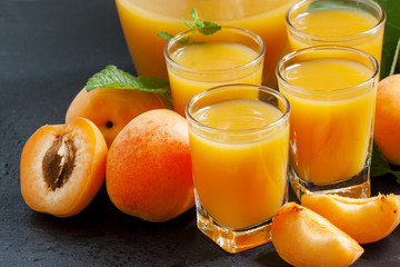 Fresh apricot juice and apricots with mint on black background,