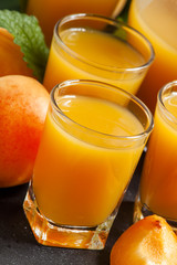 Fresh apricot juice and apricots with mint on black background,