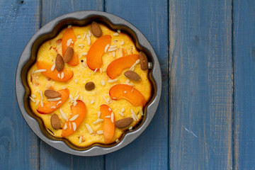 cake with almond and fruits in dish on blue background