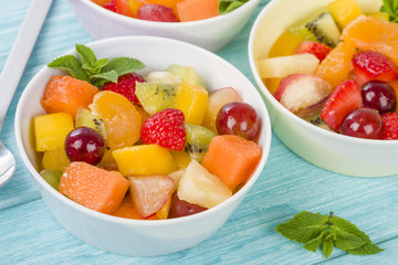 Fruit Salad - Bowls of fresh fruit salad on a blue background.