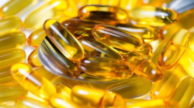 fish oil pills on tablespoon closeup