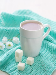 Cup of cocoa and sugar on the mint background