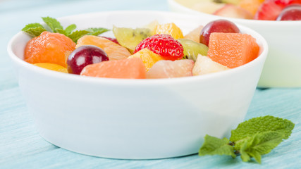 Fruit Salad - Bowls of fresh fruit salad on a blue background.