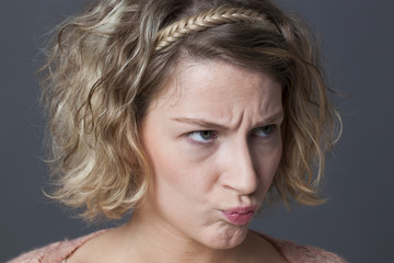 closeup portrait of cute 20s girl frowning, disappointed and angry at something or someone