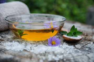 Spa and wellness setting with sea salt, oil essence, flowers 