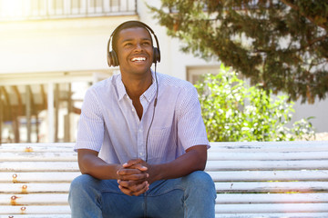 Fototapeta premium Young man smiling outside with headphones