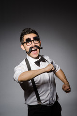 Young man with false moustache isolated on gray