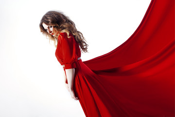Woman in dress  lies on a red background,   looking down  