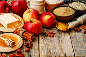 baking wood background with apples, nuts, honey, flour and butte